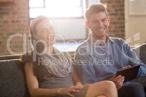 Young colleagues sitting on sofa in office