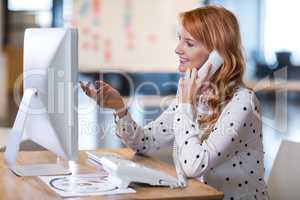 Businesswoman talking on telephone in office