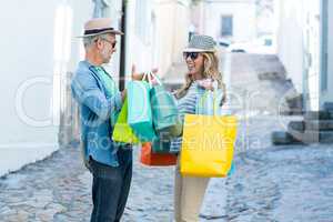 Happy mature couple holding shopping bags