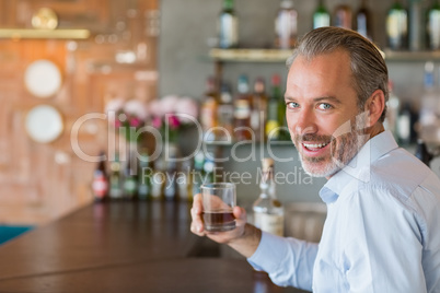 Portrait of man holding glass of whiskey