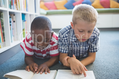 School kids reading book in library
