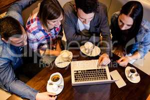 Friends using laptop at restaurant