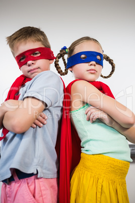 Boy and girl standing with arm crossed and pretending to be a su