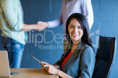 Young businesswoman with colleagues shaking hands