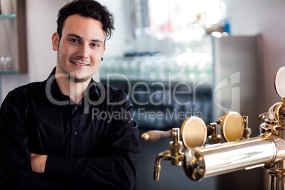 Confident bartender standing at bar counter