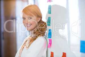 Beautiful businesswoman leaning on whiteboard