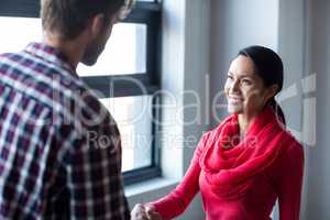 Colleagues shaking hands in office