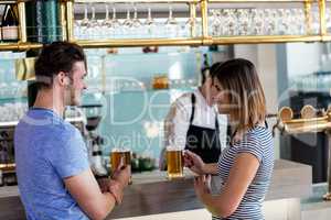 Couple smiling while having beer at counter