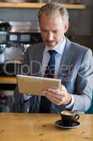 Close-up of businessman using digital tablet in cafÃ©