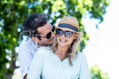 Happy couple embracing against trees