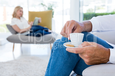 Midsection of man having coffee at home