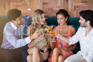 Group of friends toasting glasses of cocktail