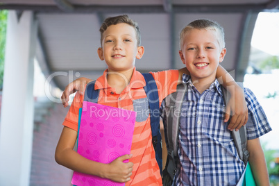 Smiling schoolkids standing in corridor