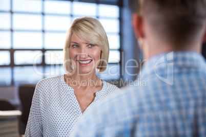 Businesswoman standing in front of male colleague