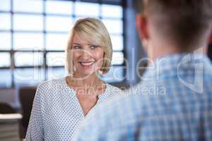 Businesswoman standing in front of male colleague