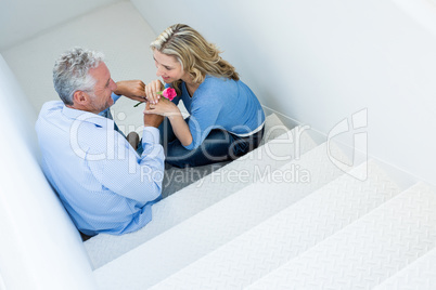 High angle view of man giving rose to woman