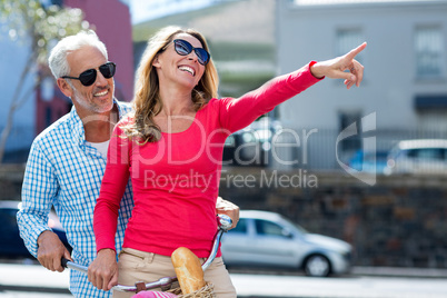 Happy man with woman pointing at city street