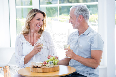 Mature couple holding champagne at restaurant