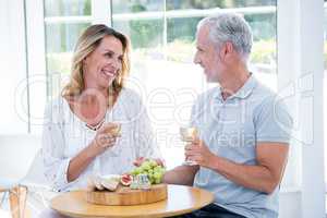 Mature couple holding champagne at restaurant