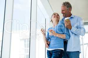 Low angle view of mature couple with disposable coffee cups