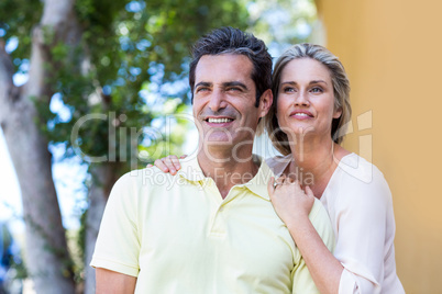 Happy couple standing by building