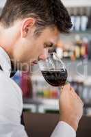 Waiter smelling a glass of wine
