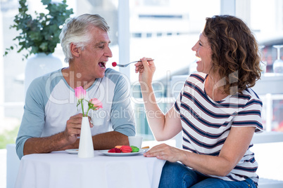 Happy woman feeding food to man