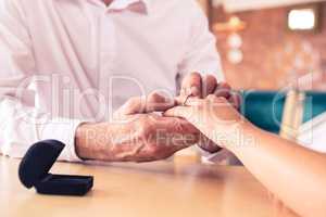 Man putting engagement ring on womans finger