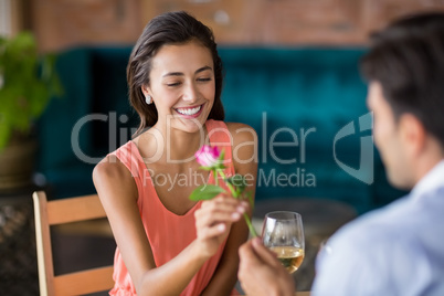 Man giving red rose to woman