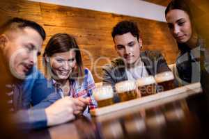 Friends looking at beer glasses in restaurant