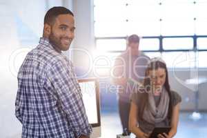 Happy businessman while colleagues in background