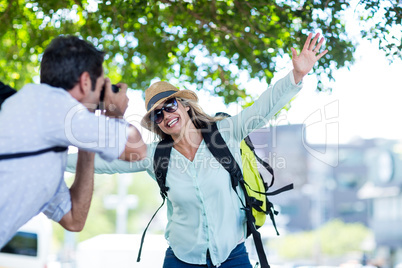 Man photographing cheerful woman