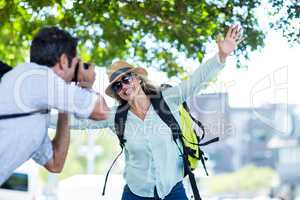 Man photographing cheerful woman