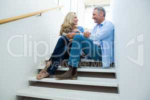 Smiling couple sitting on steps