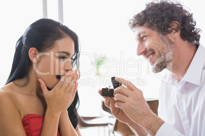Man surprising woman with a engagement ring