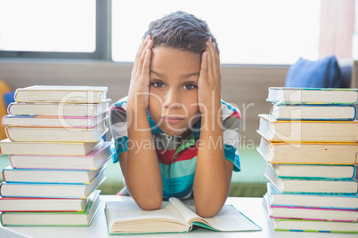 Schoolboy reading a book in library