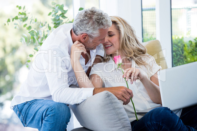 Romantic mature man giving rose to woman