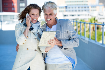 Smiling woman with man using digital tablet