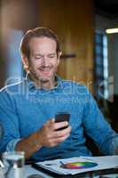 Businessman using cellphone at desk