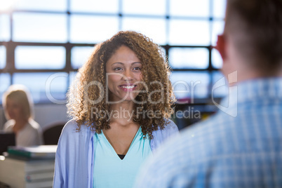 Businesswoman standing in front of male coworker