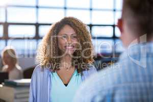 Businesswoman standing in front of male coworker