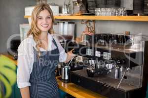 Portrait of smiling waitress making cup of coffee