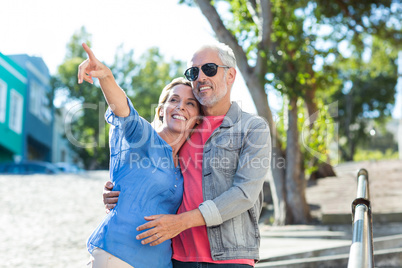 Mature man with woman on footpath in city