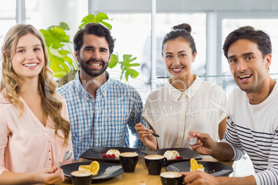 Group of happy friends having dessert together