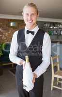 Portrait of waiter holding a bottle of champagne
