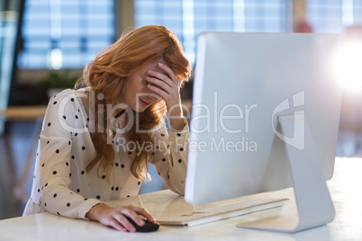 Stressed businesswoman suffering from headache in office