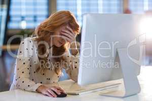 Stressed businesswoman suffering from headache in office