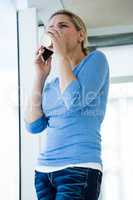 Low angle view of woman having drink while talking on phone