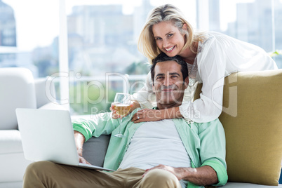 Portrait of couple using laptop at home