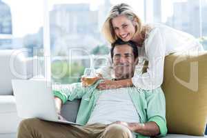 Portrait of couple using laptop at home